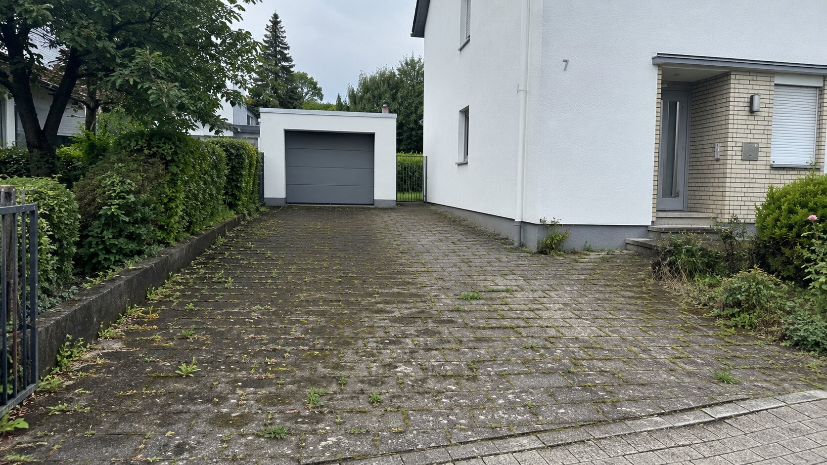 Verschmutzte Einfahrt mit Moos und Algen vor der Reinigung